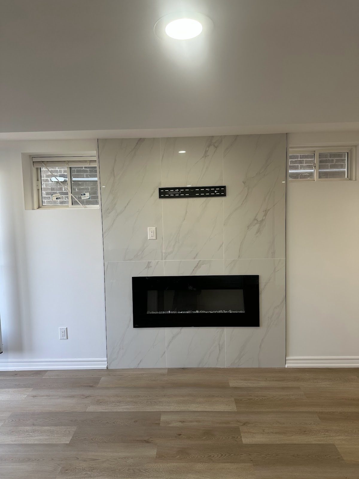 Real completed basement finishing with fireplace feature wall