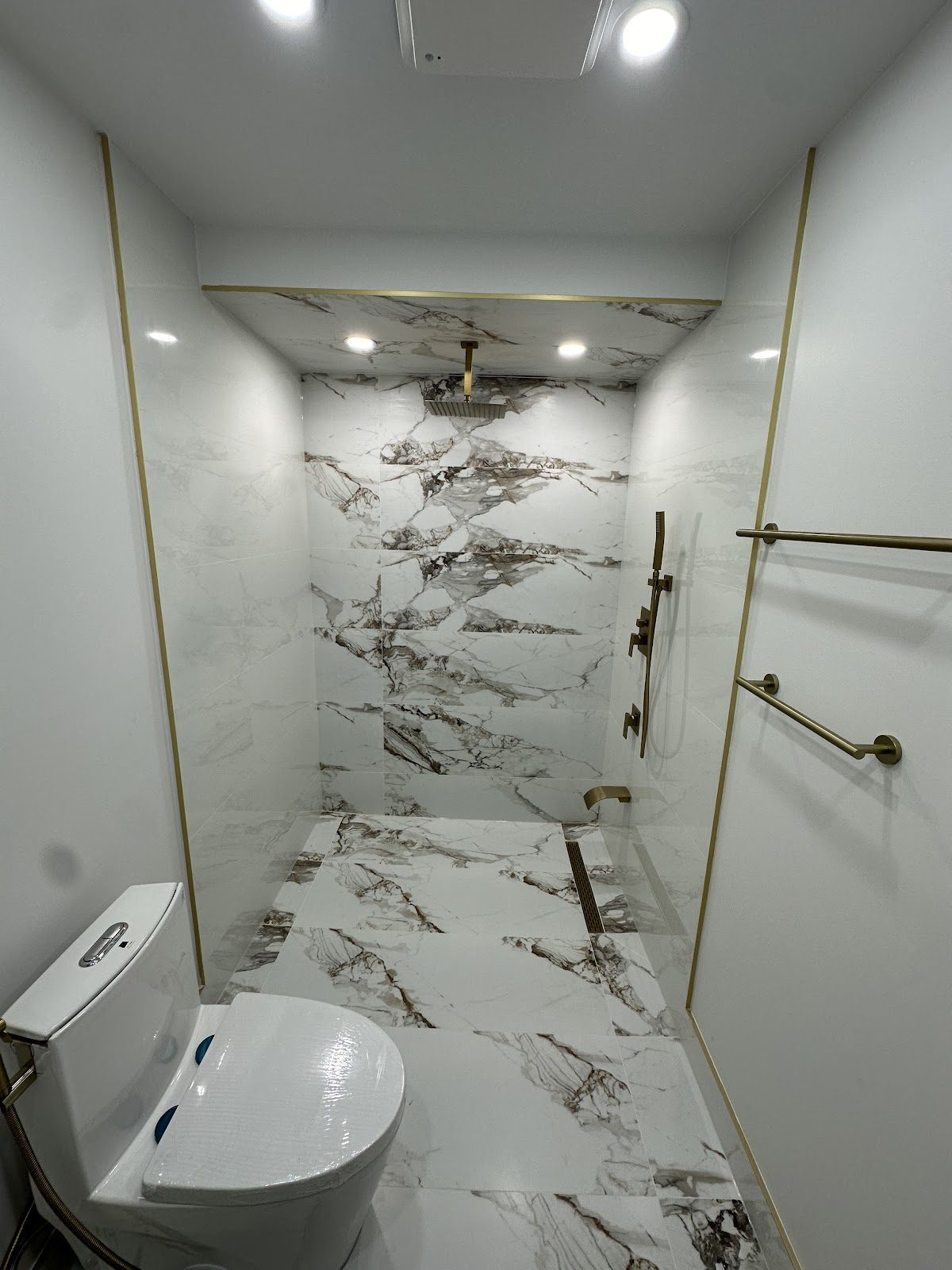 Real completed bathroom renovation, gold marble shower